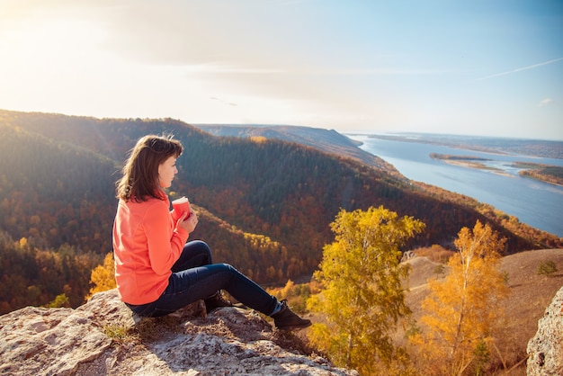 Photo the girl is drinking tea on top of the mountain