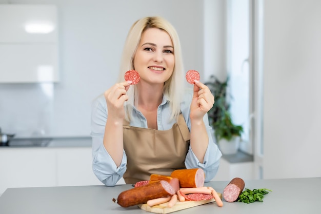 The girl is eating sausage. A piece of sausage. Smile and Joy. Business concept is the brand's appeal. Appetite