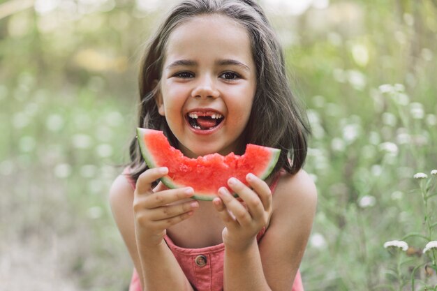 The girl is eating a watermelon. Summer mood.