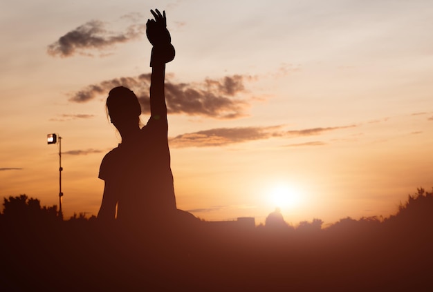 The girl is engaged in aerobics on a sunset background. silhouette