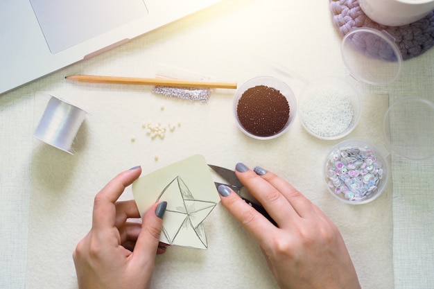 Girl is engaged in creative activity. Making brooch. Flat lay