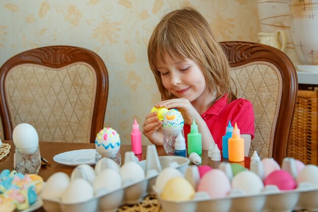 Foto la ragazza si diverte a dipingere le uova per pasqua.