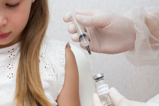 The girl is given a vaccine. Covid-19