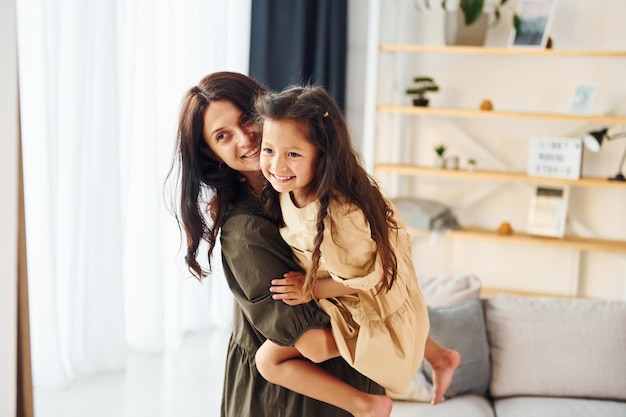 Girl is on the hands of woman Mother and her daughter spending time together at home