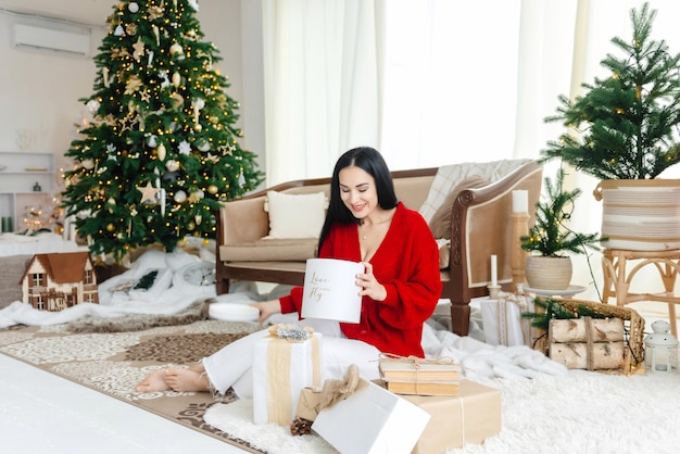 The girl is happy with her new years present young girl sitting\
among christmas presents