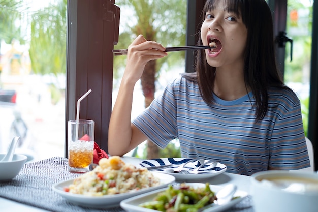 女の子がレストランで美味しい食事をしている。