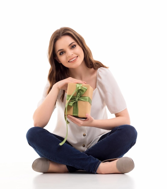 The girl is holding a box with a gift in her hands