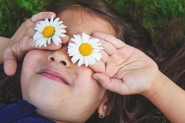소녀는 그녀의 손에 카모마일 꽃을 들고 있다. 선택적 초점입니다. 자연.