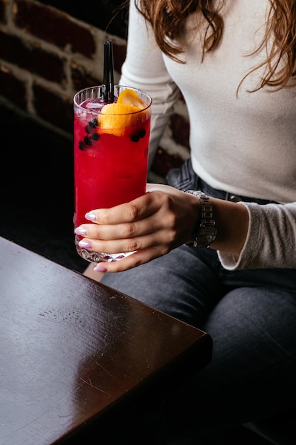 The girl is holding a cocktail in her hands berry cocktail bar