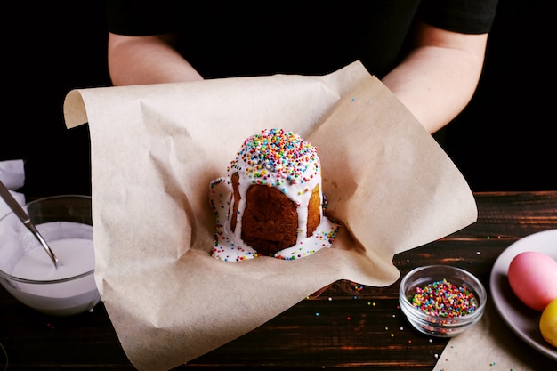 The girl is holding Easter baked goods with icing and colored powder