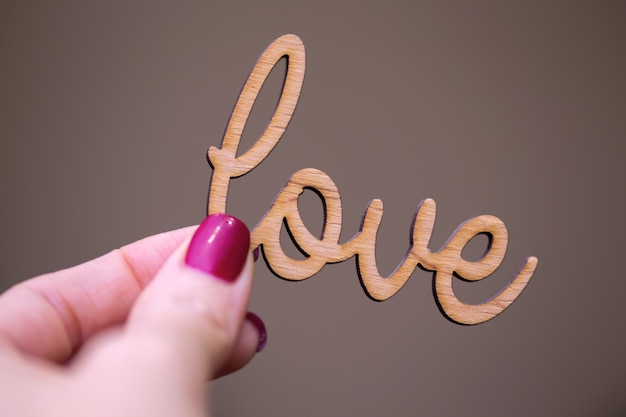 Photo the girl is holding the inscription love in her hand