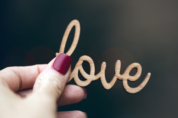 Photo the girl is holding the inscription love in her hand