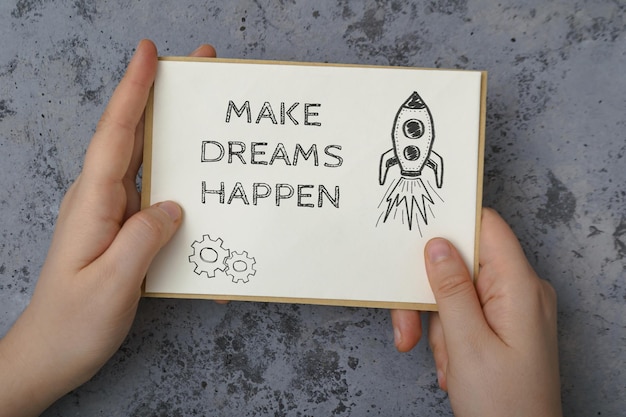 The girl is holding a letter in her hands with the text make dreams happen motivational quote writte