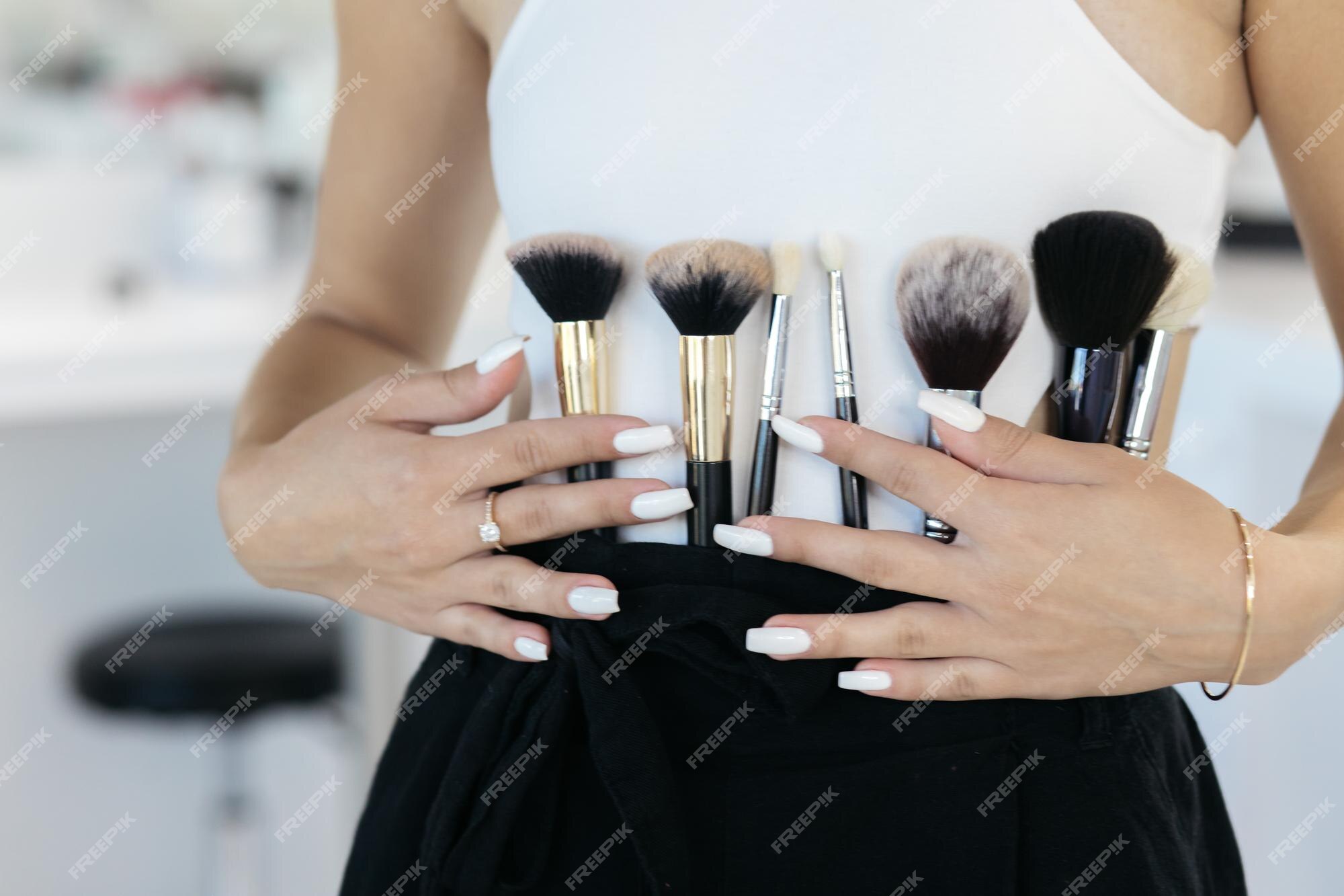 rim Blive gift vride Premium Photo | The girl is holding makeup tools professional makeup artist  with a belt bag with tassels makeup brushes professional makeup artist  doing glamour model makeup at work