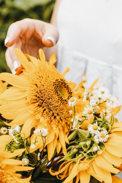 Girl is holding a sunflower bouquet