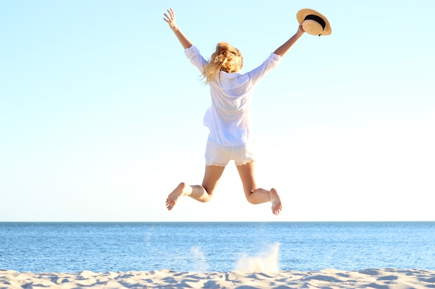 The girl is jumping against the sea