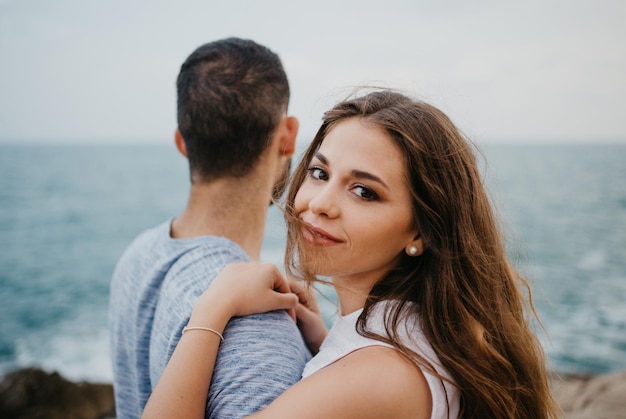 A girl is keeping her hands on the shoulder of her boyfriend on the rocky hill