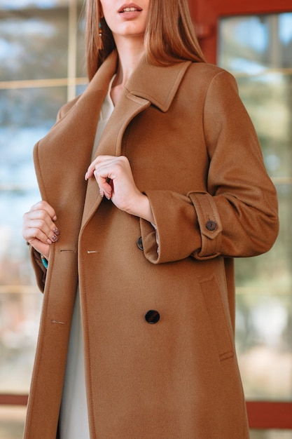 Photo the girl is a model showing fashionable outerwear on the street on the veranda of a summer cafe clothes for the showroom