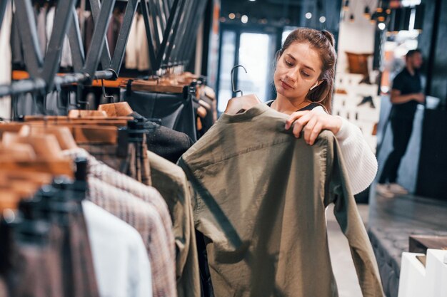 Girl is in modern store with new clothes Elegant expensive wear