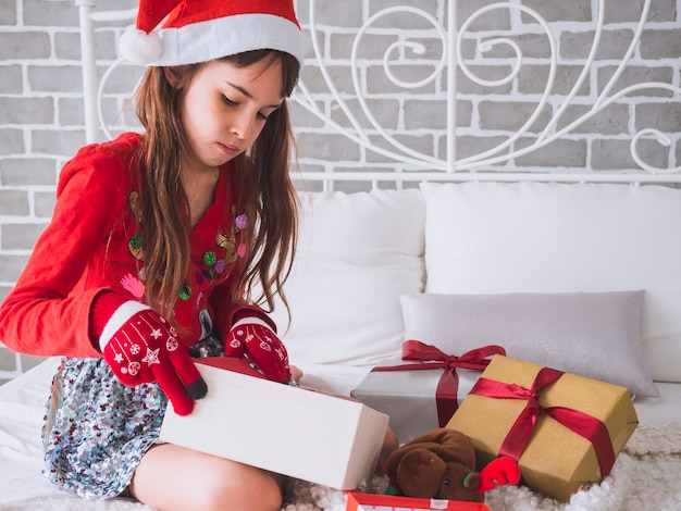 Foto la ragazza sta aprendo la confezione regalo il giorno di natale