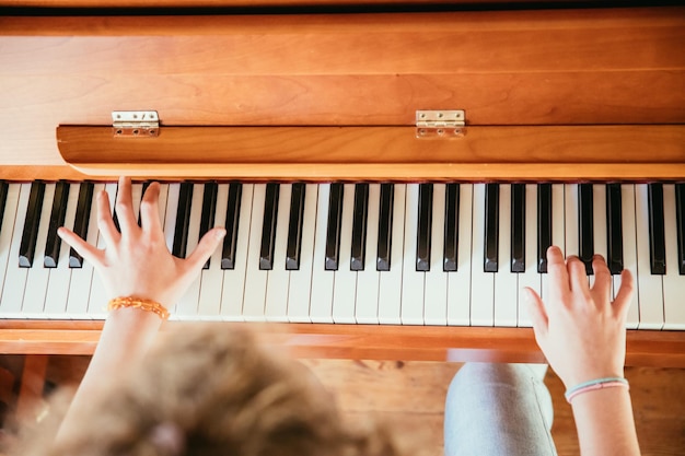 Девушка играет на пианино дома под высоким углом зрения размытый фон