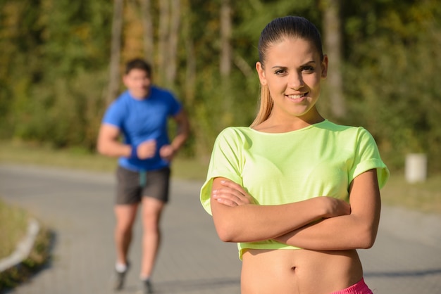 Girl is posing while the guy is catching up.