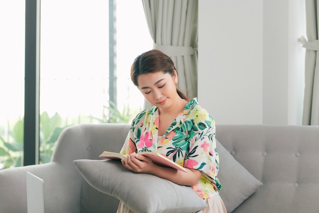 A girl is reading a book at home