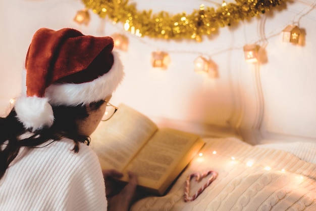 Photo the girl is reading a book lying on the bed