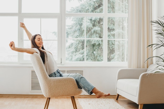 The girl is resting after work sitting in a chair and enjoys peace and quiet