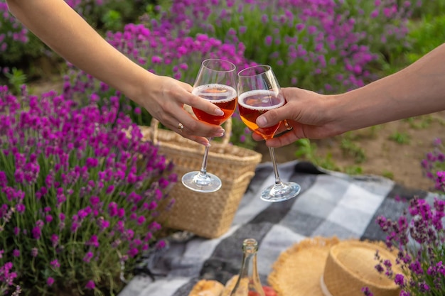 The girl is resting in a lavender field drinking wine Selective focus