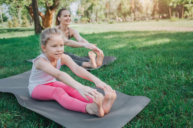 Girl is sitting in front and stretching her body