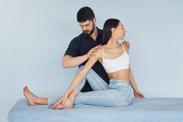 Girl is sitting Physiotherapist works with young woman indoors in the spa