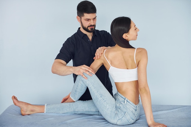 Girl is sitting Physiotherapist works with young woman indoors in the spa