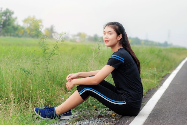 Girl is sitting on road.