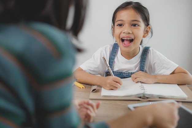 a girl is sitting at a table with a pen and a notebook