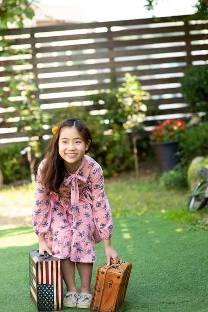 The girl is smiling happily with her suitcase.