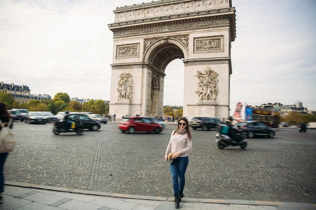 Girl is standing neat the arch of triumphal