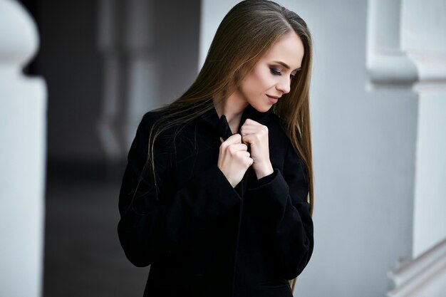 A girl is standing in profile and looking down.