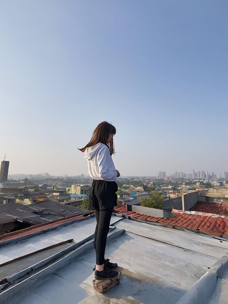 Photo a girl is standing on the roof