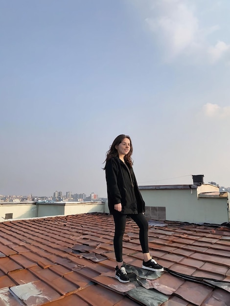 Foto una ragazza è in piedi sul tetto