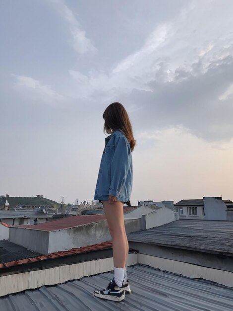 Photo a girl is standing on the roof