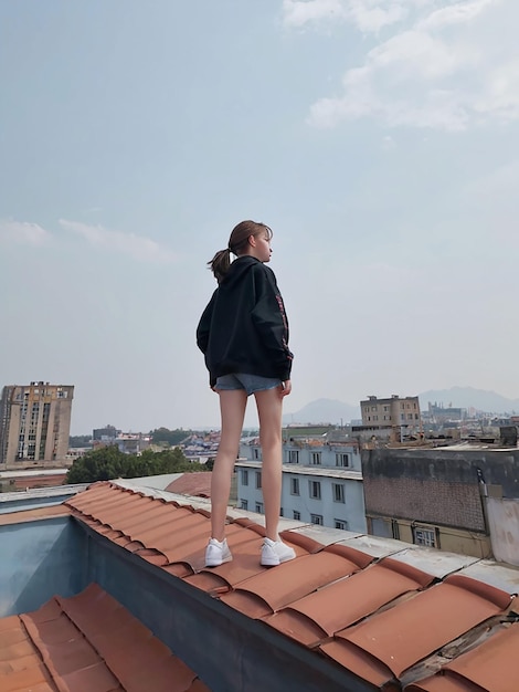 Photo a girl is standing on the roof