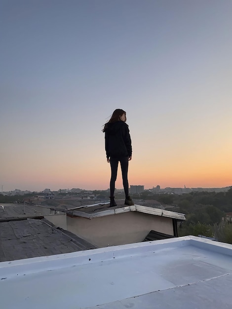 Photo a girl is standing on the roof