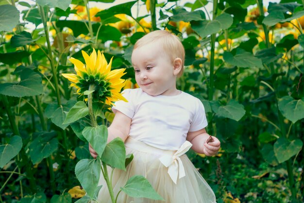 The girl is standing among the sunflowers