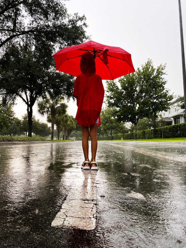 Photo a girl is standing with umbrella under the rain