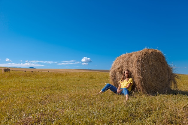 A girl is sunbathing in the hay. village life: harvesting hay for the winter. animal feed.