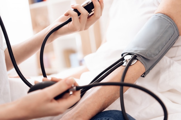 Girl is using tonometer to measure blood pressure.