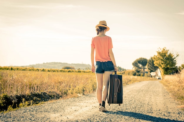 사람, 휴일 및 라이프 스타일 개념-소녀는 그녀의 휴가 기간 동안 그녀의 가방과 함께 걷고있다