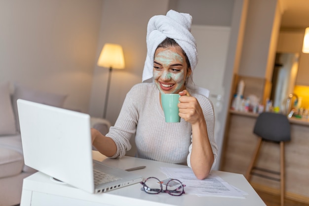 Photo girl is working from home, she has face mask and she is in the bath robe.