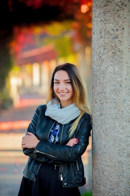 Ragazza in giacca vicino alla colonna